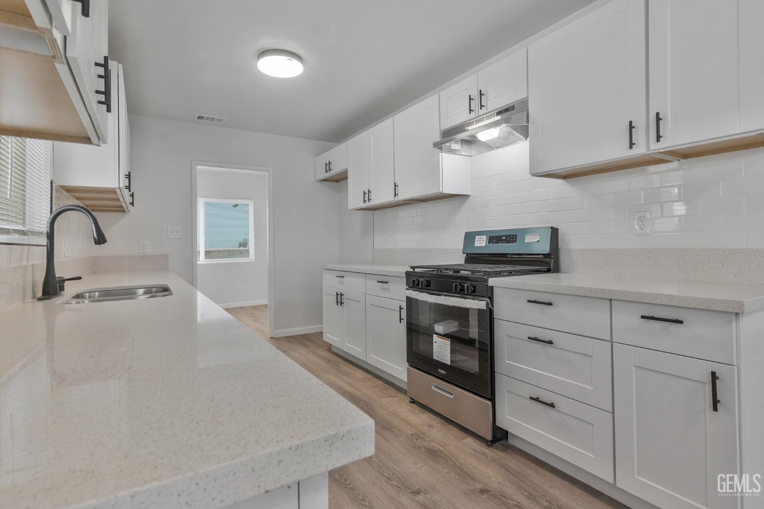 Undisclosed Address Bakersfield, CA 93304 - Photo 22 of 29 a kitchen with white cabinets stainless steel appliances and sink