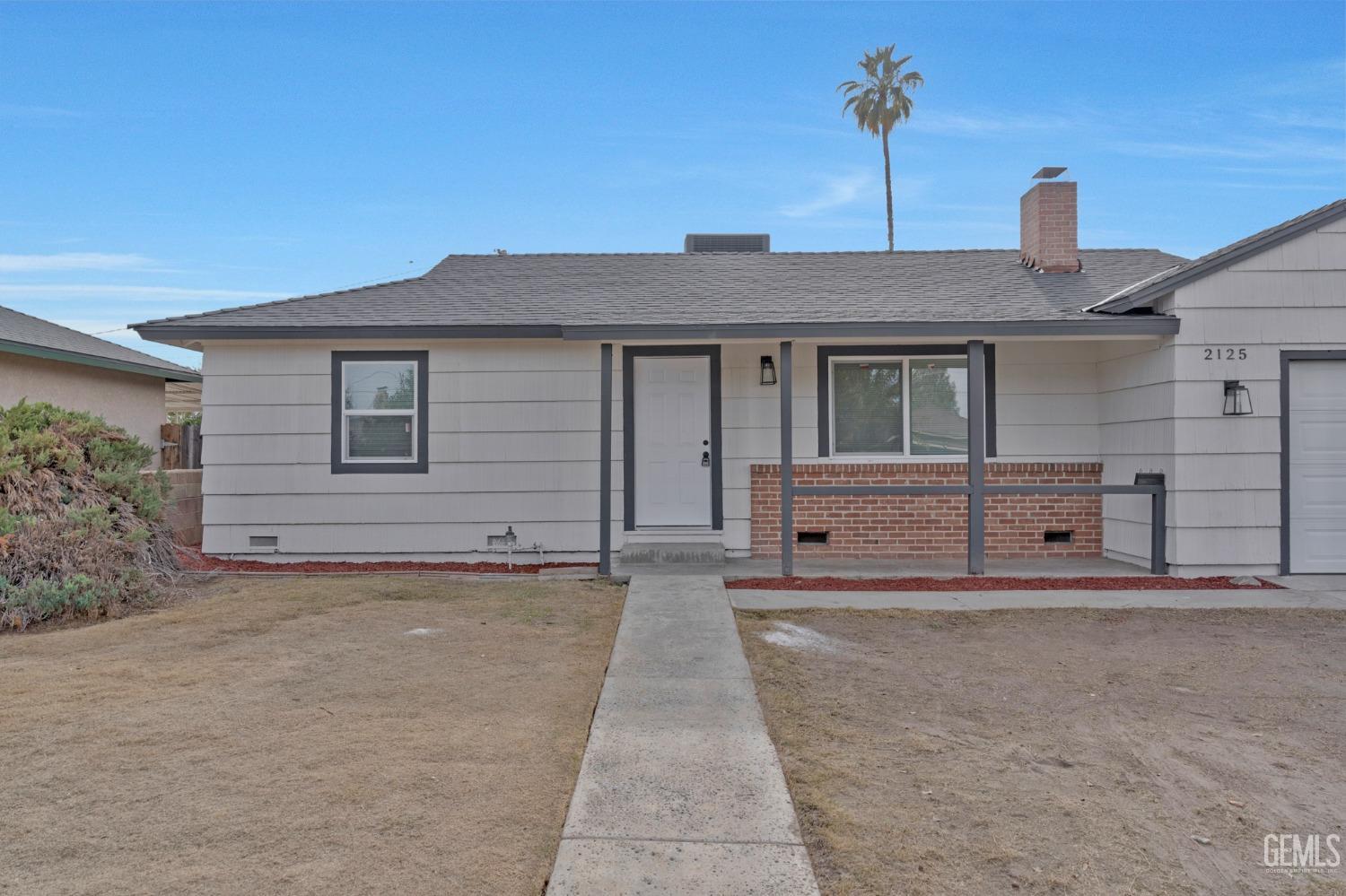 Undisclosed Address Bakersfield, CA 93304 - Photo 3 of 29 a front view of a house with a yard and garage
