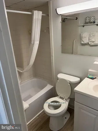 a white toilet sitting next to a bath tub