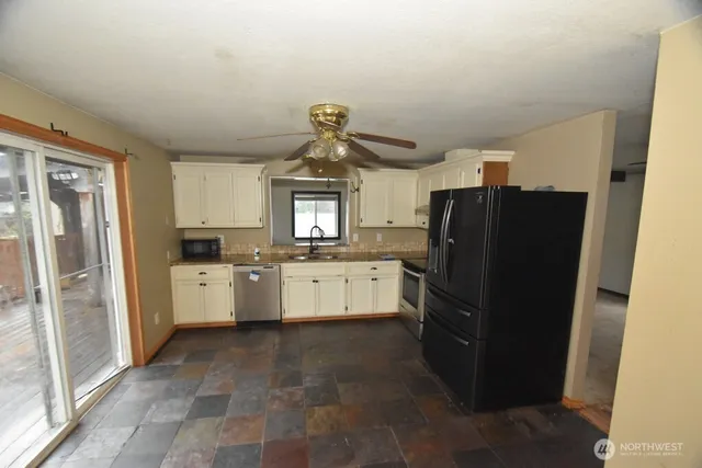 a kitchen with a refrigerator and white cabinets