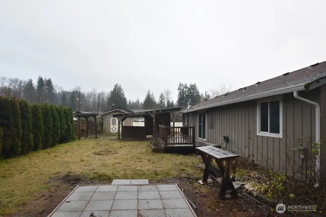a view of a house with backyard and sitting area