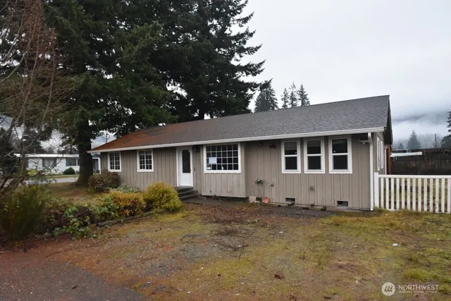a view of a house with a yard and large tree