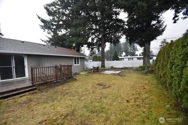 a view of a house with a yard and wooden fence