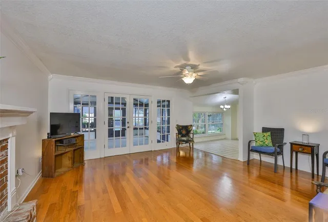 a large living room with stainless steel appliances furniture a fireplace and a kitchen view