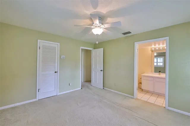 a view of a livingroom with a chandelier fan and a bathroom