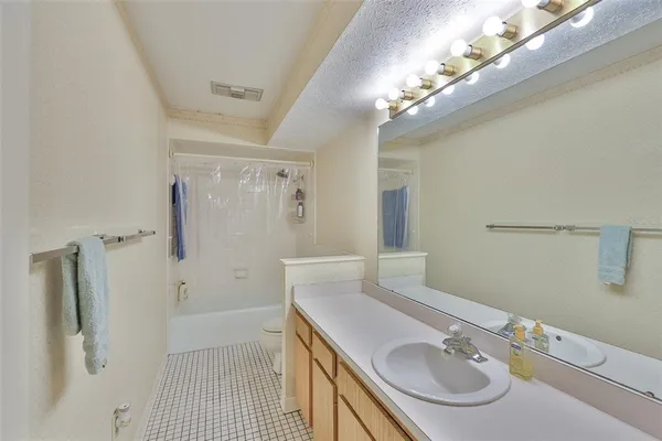 a bathroom with a sink shower and a mirror