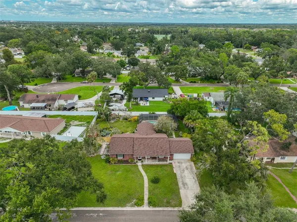 an aerial view of residential houses with outdoor space and trees