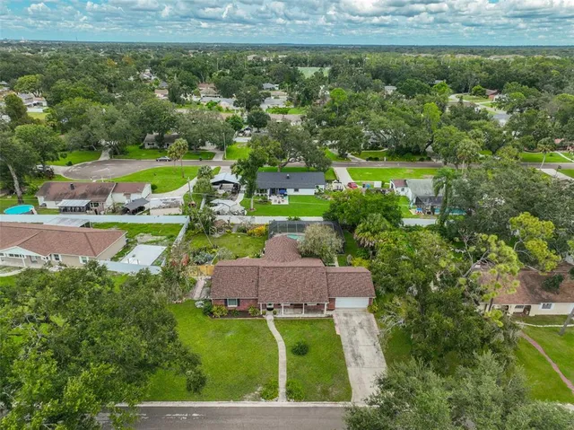 an aerial view of residential houses with outdoor space and trees