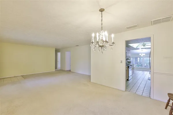 a view of a chandelier in big room and a bathroom