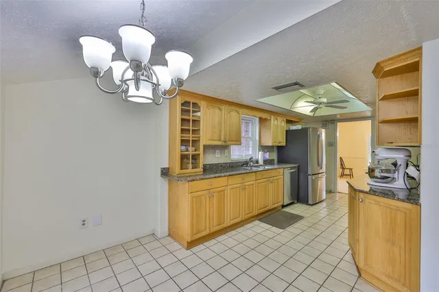a kitchen with stainless steel appliances granite countertop a sink a stove top oven a counter space and cabinets