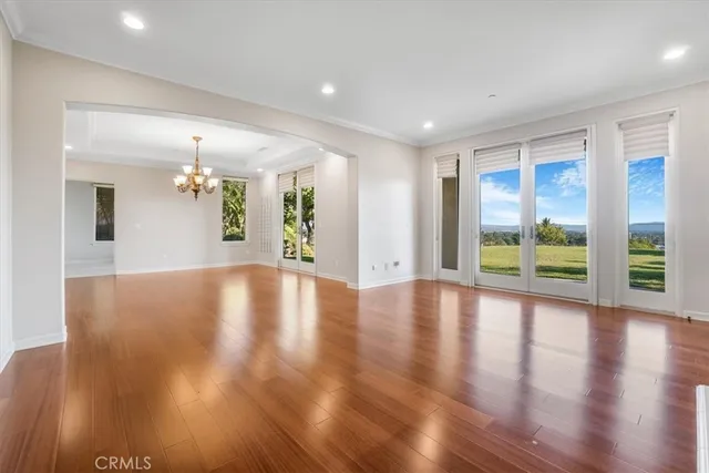a view of a room with wooden floor and chandelier