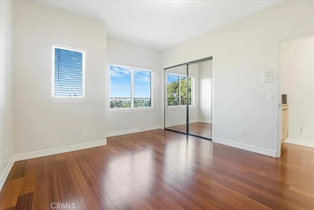an empty room with wooden floor and a bathroom