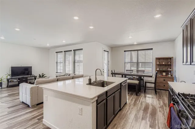a kitchen with stainless steel appliances granite countertop a sink stove and wooden floor