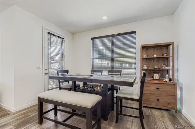a view of a a dining room with furniture window and wooden floor
