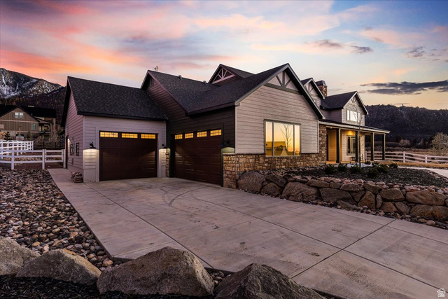 1210 East Bristle Cone Road Pine Valley, UT 84781 - Photo 36 of 54 View of front of house featuring driveway, a garage, stone siding, a chimney, and covered porch