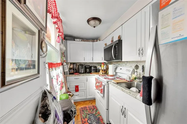 a utility room with stainless steel appliances granite countertop a stove and a sink