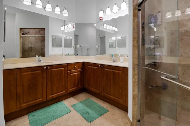 a spacious bathroom with a sink a large mirror and a shower