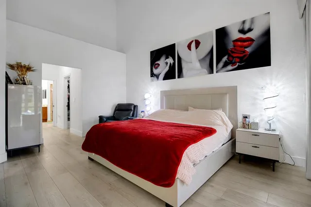 a bedroom with bed and painting on the wall