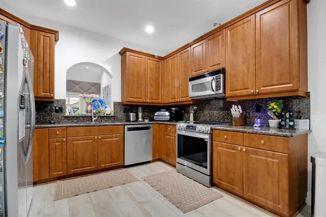 a kitchen with stainless steel appliances granite countertop a stove sink and cabinets