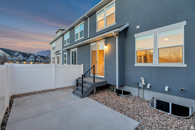 1058 Lilac Way Mapleton, UT 84664 - Photo 25 of 28 Exterior entry at dusk featuring stucco siding, a residential view, and a patio