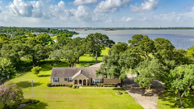 a view of a swimming pool with lawn chairs next to yard