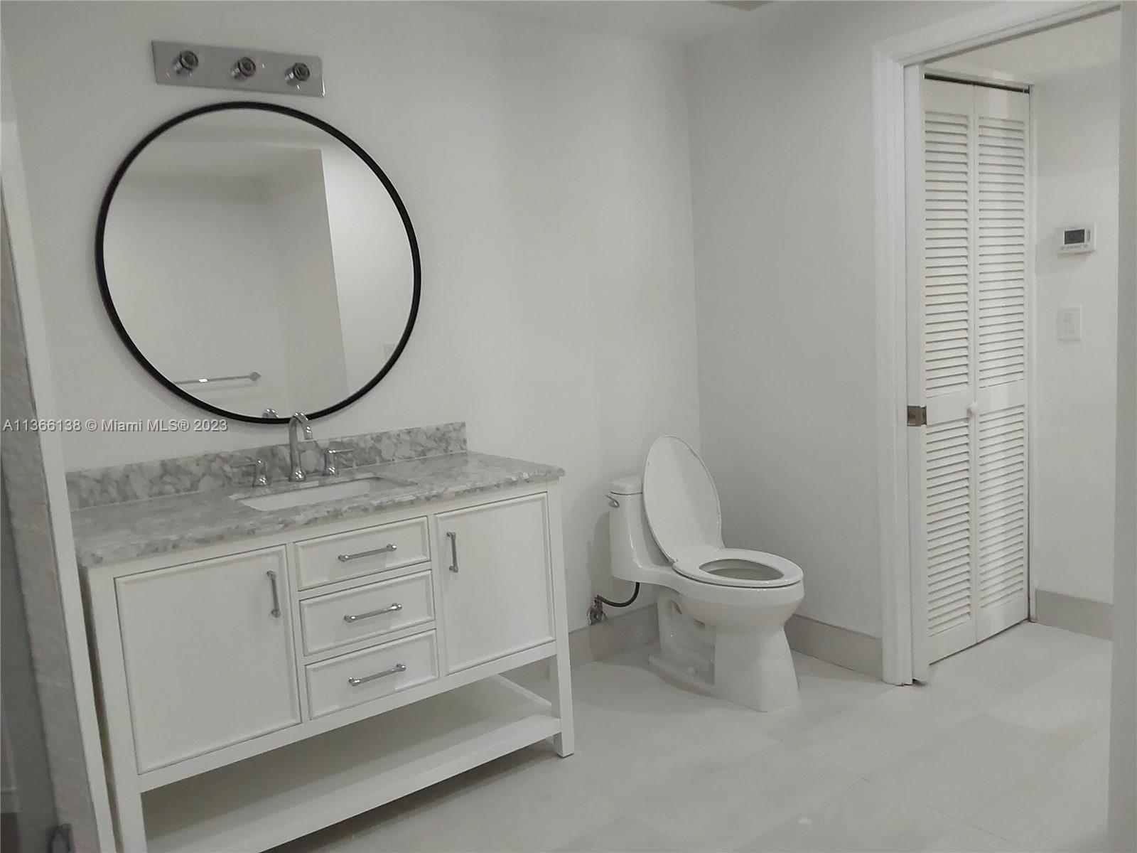 La Gorce Miami Beach, FL 33140 - Photo 14 of 33 a bathroom with a granite countertop toilet sink and mirror