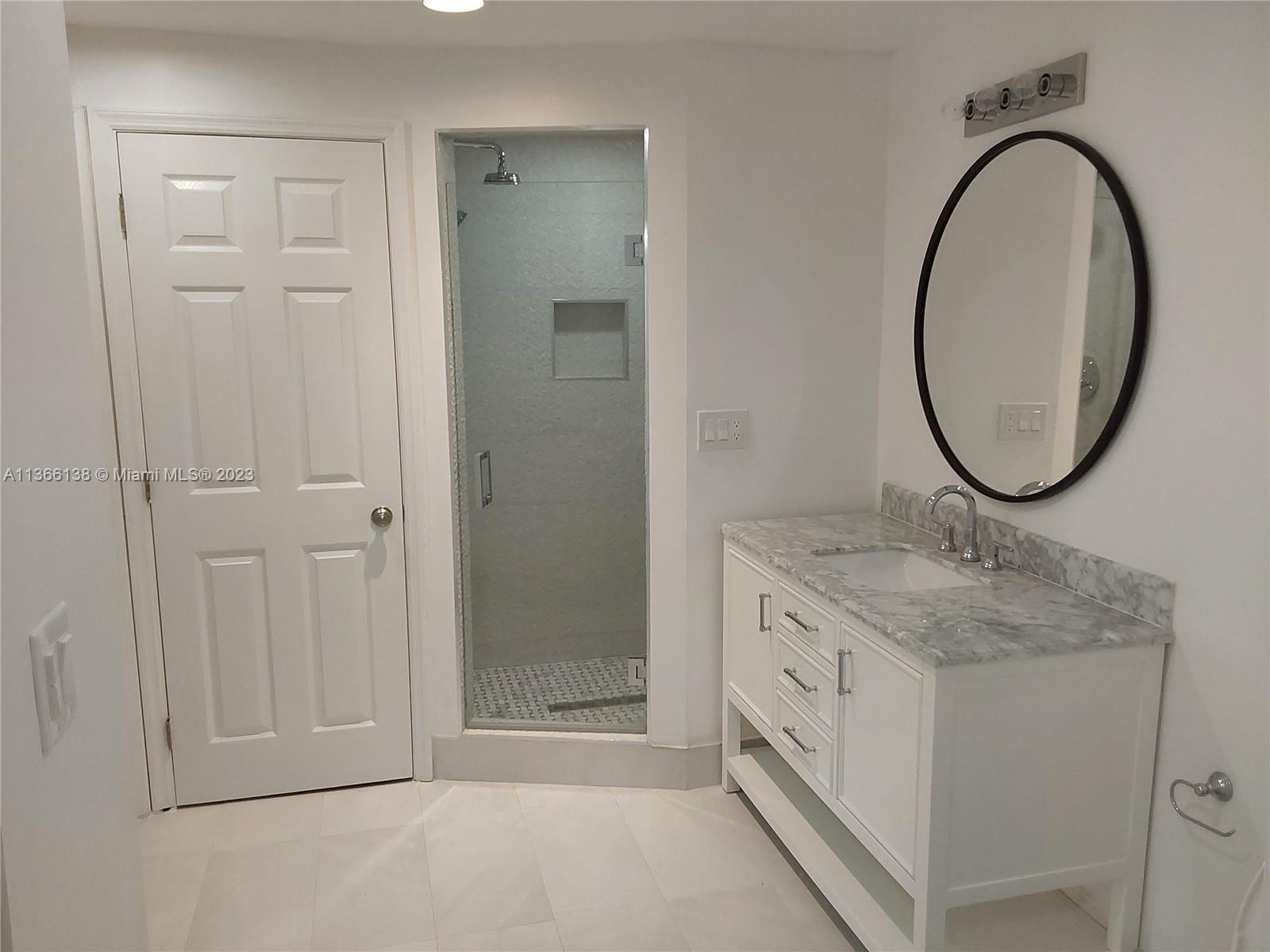 La Gorce Miami Beach, FL 33140 - Photo 19 of 33 a bathroom with a granite countertop sink a mirror and a shower
