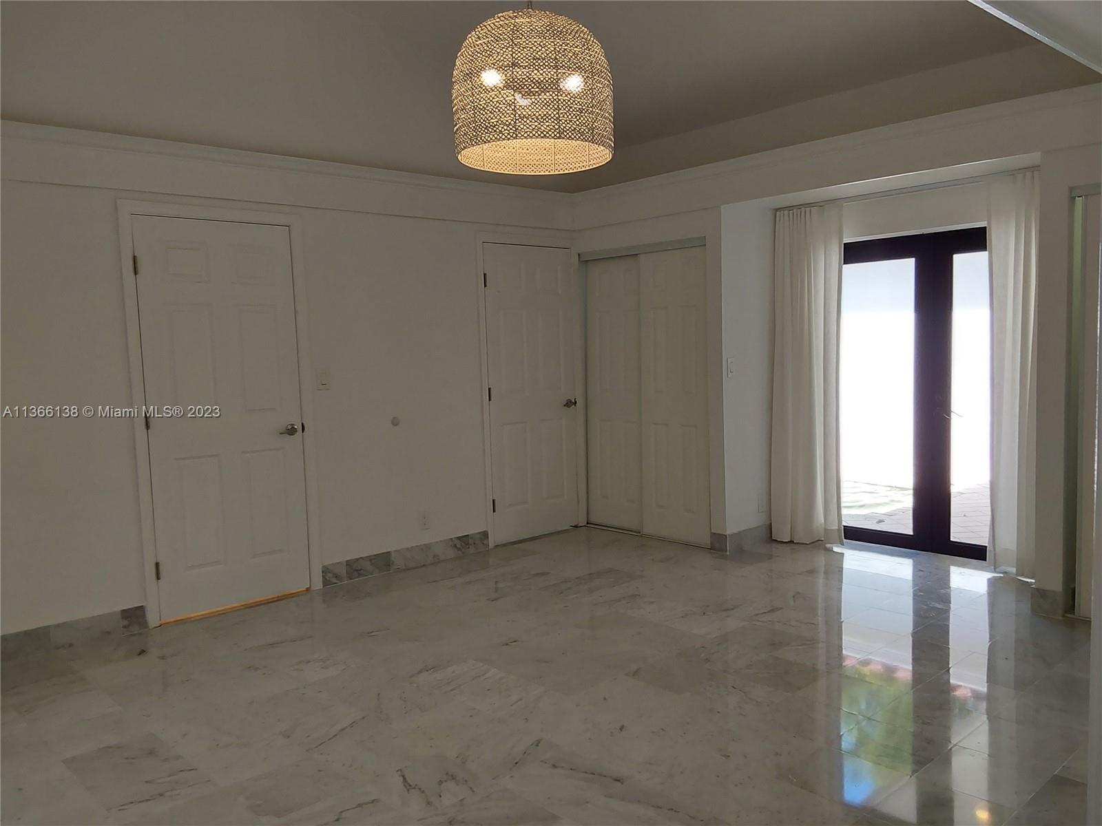 La Gorce Miami Beach, FL 33140 - Photo 26 of 33 an empty room with wooden floor and windows