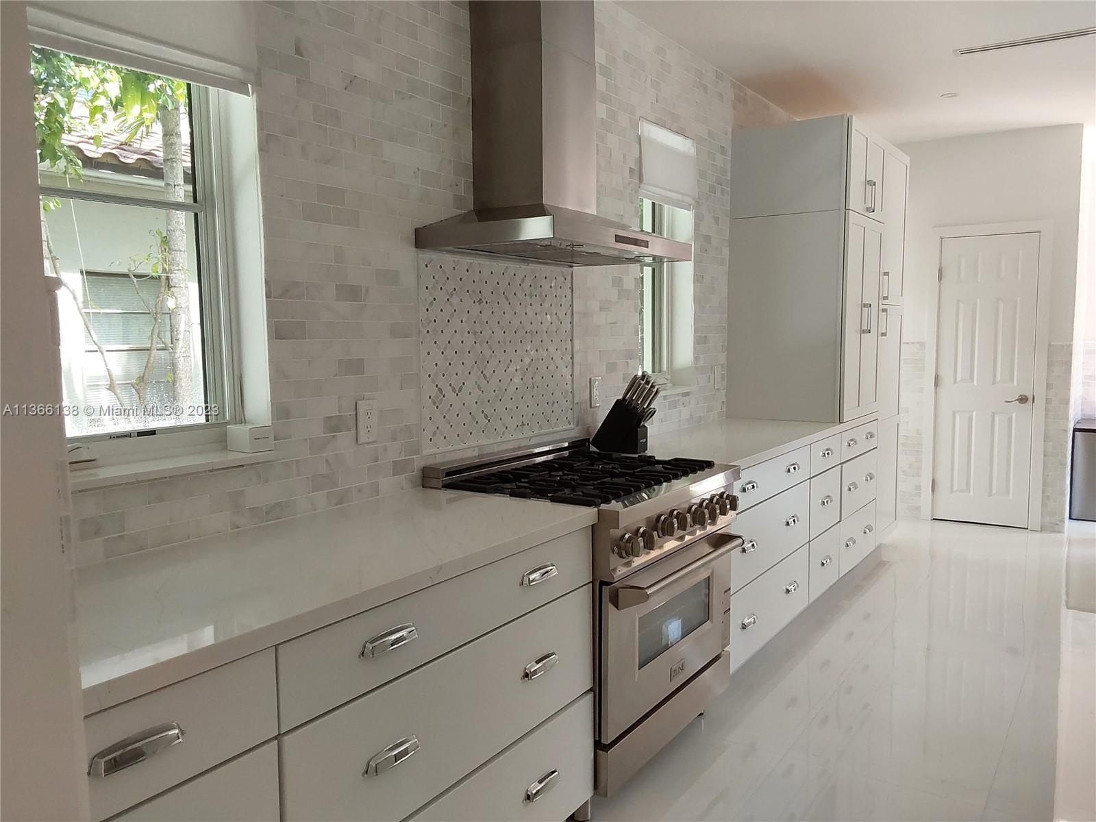 La Gorce Miami Beach, FL 33140 - Photo 4 of 33 a kitchen with white cabinets and appliances