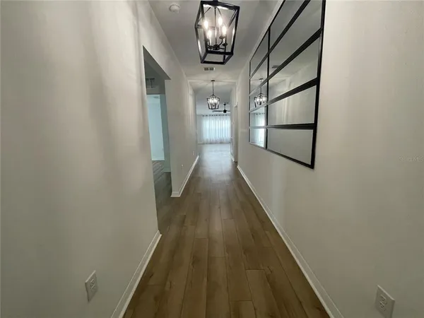 a view of a hallway with wooden floor and staircase