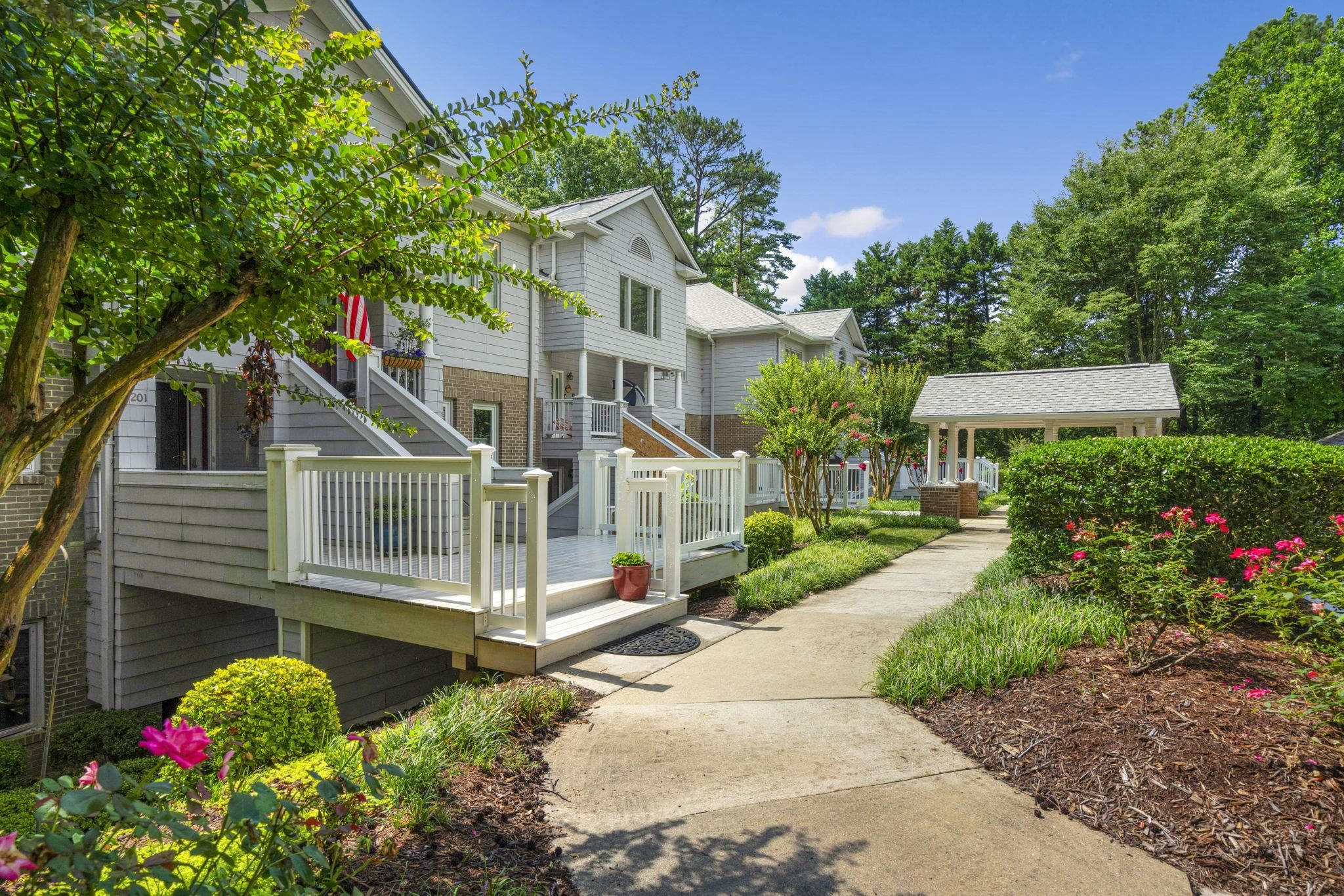 7500 Dartford Court, Unit 102 Raleigh, NC 27615 - Photo 1 of 36 a view of a house with a small yard and potted plants