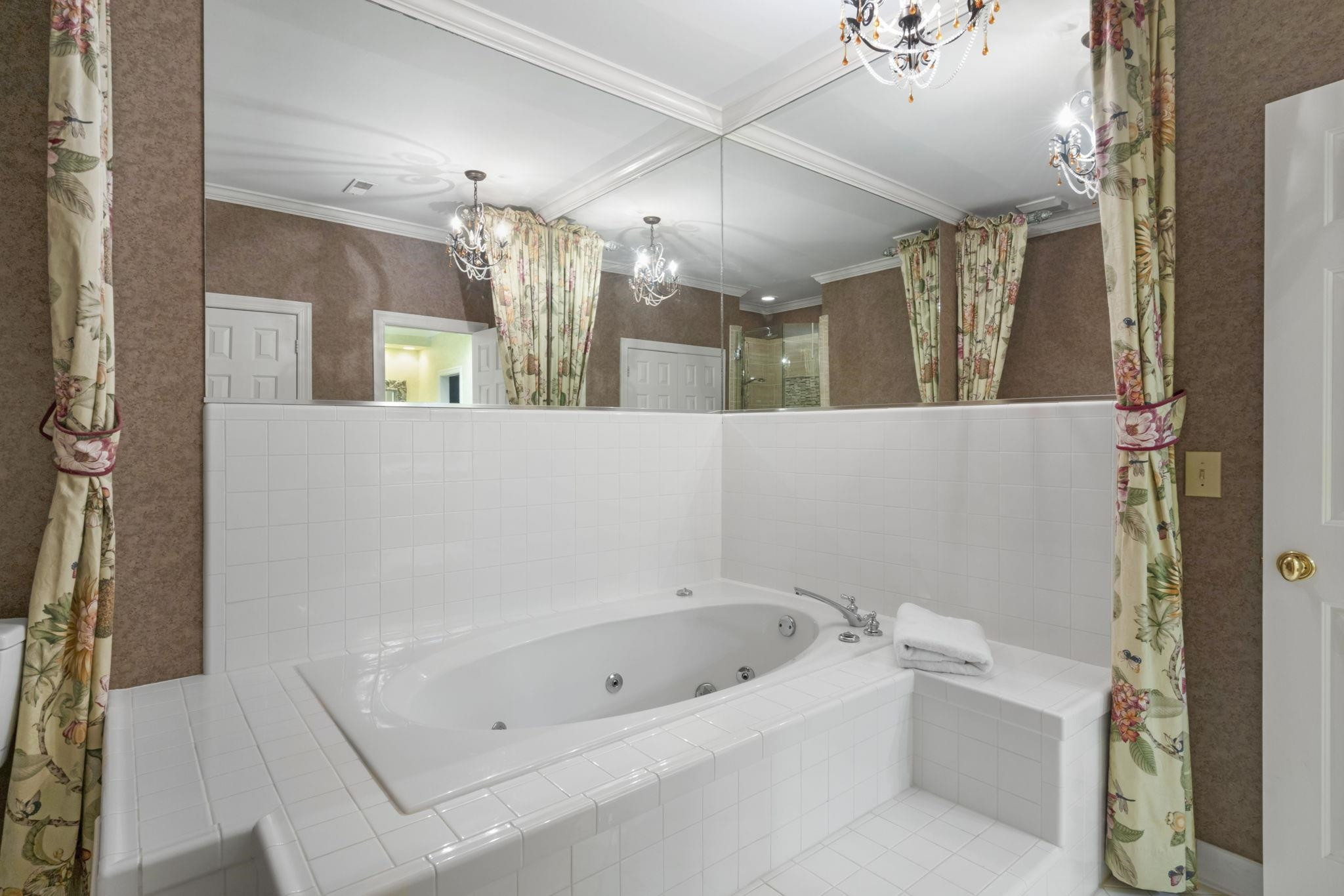 7500 Dartford Court, Unit 102 Raleigh, NC 27615 - Photo 22 of 36 a bathroom with a bathtub a mirror a vanity and a shower