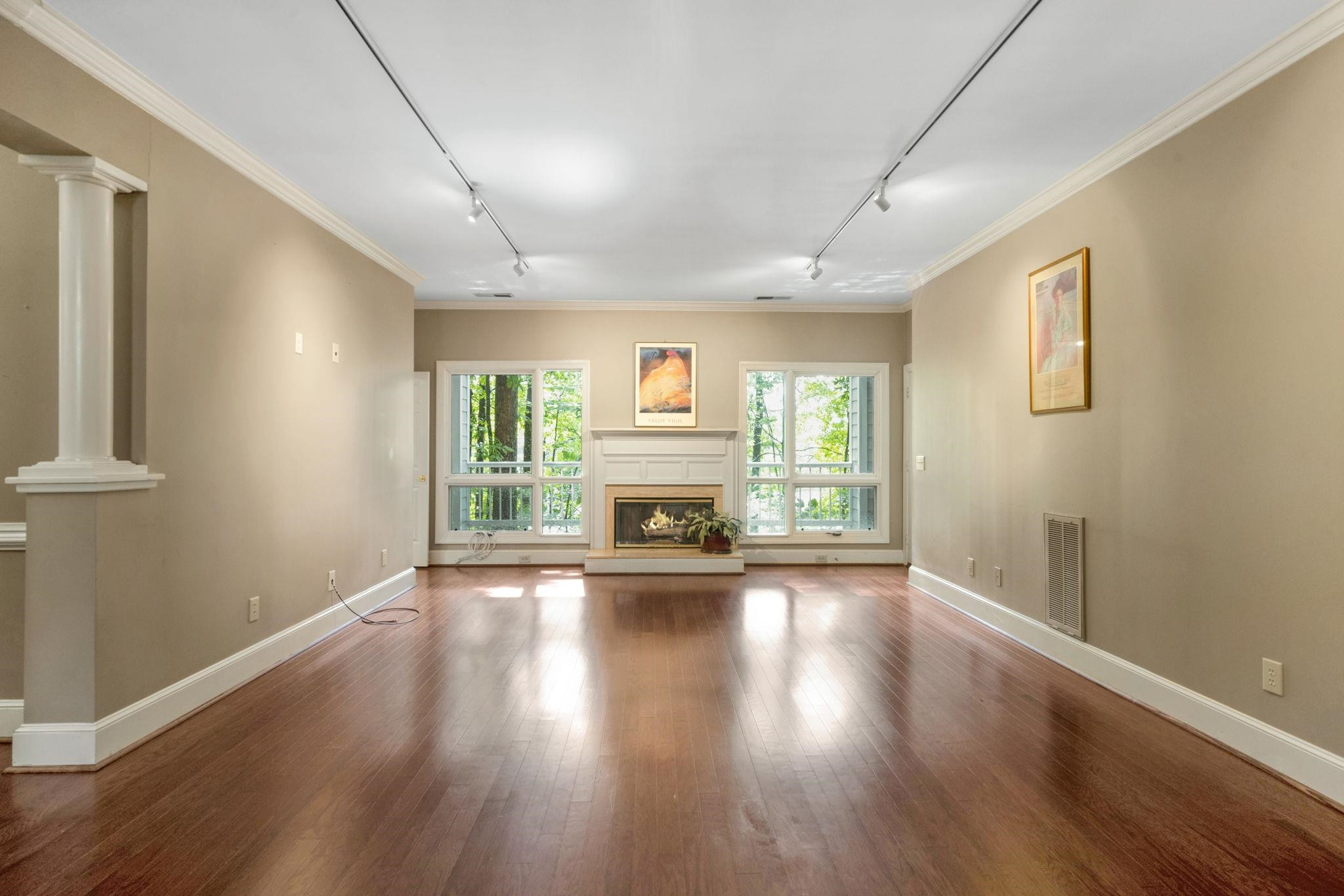 7500 Dartford Court, Unit 102 Raleigh, NC 27615 - Photo 5 of 36 an empty room with wooden floor fireplace and windows