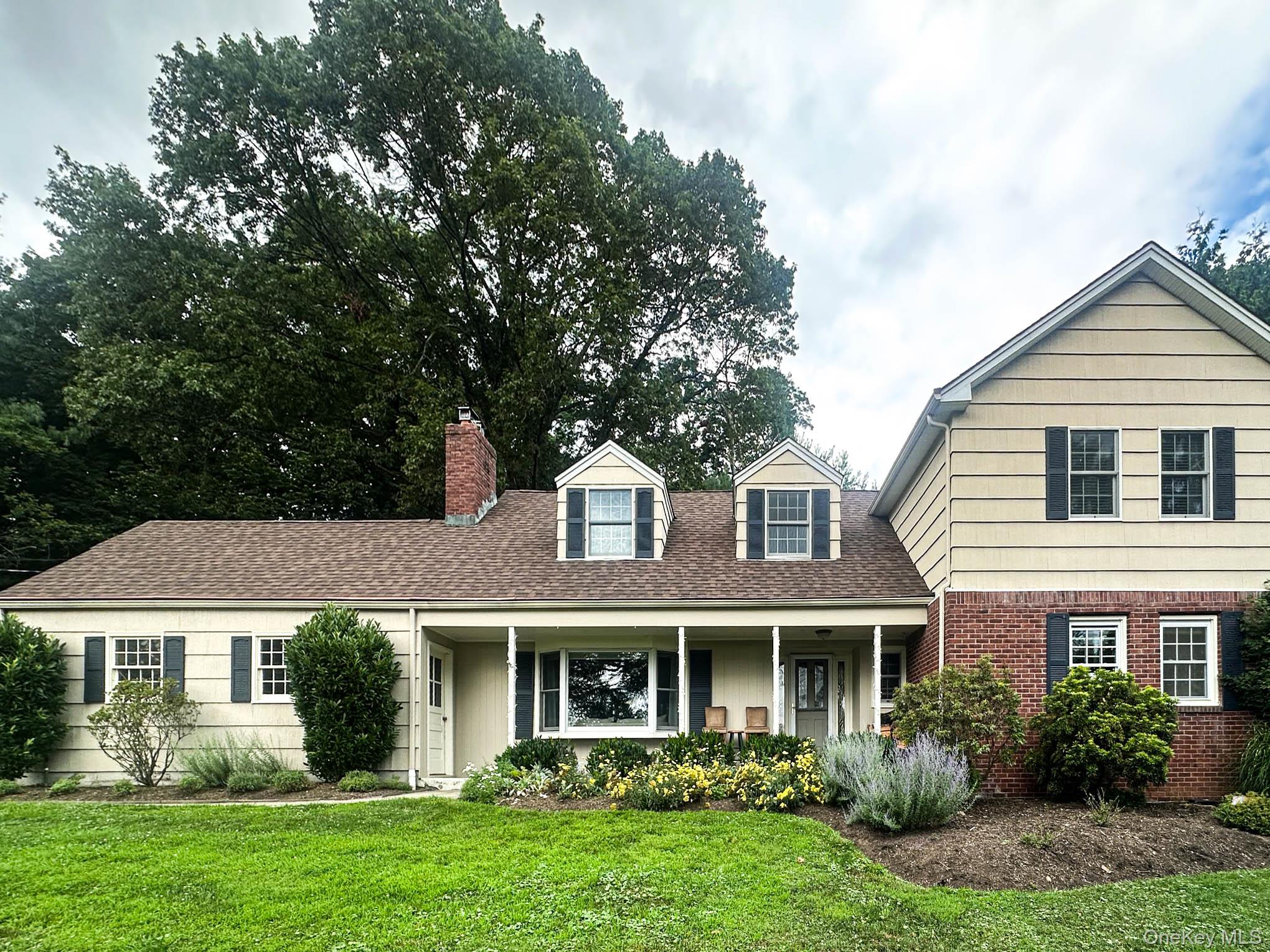 a front view of a house with a yard and trees