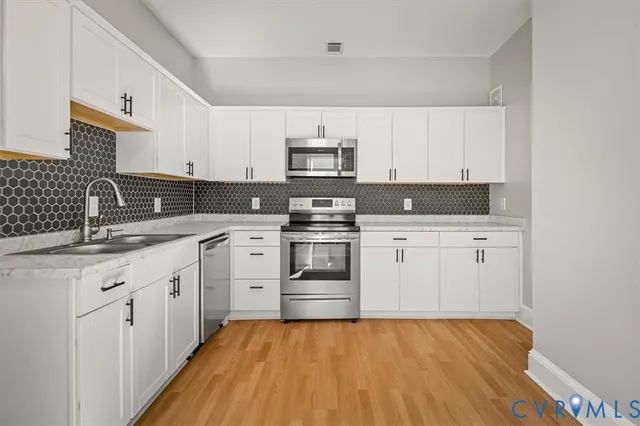 a kitchen with granite countertop white cabinets and white appliances
