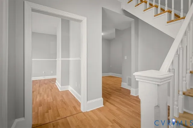 a view of front door with wooden floor and stairs