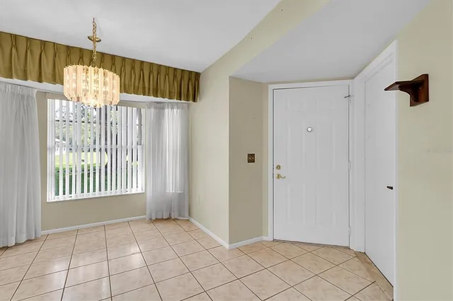 a view of a hallway with wooden floor and chandelier