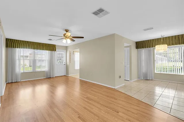a view of a room with wooden floor and a ceiling fan