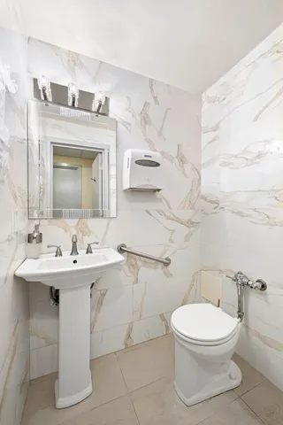 a bathroom with a toilet sink and mirror