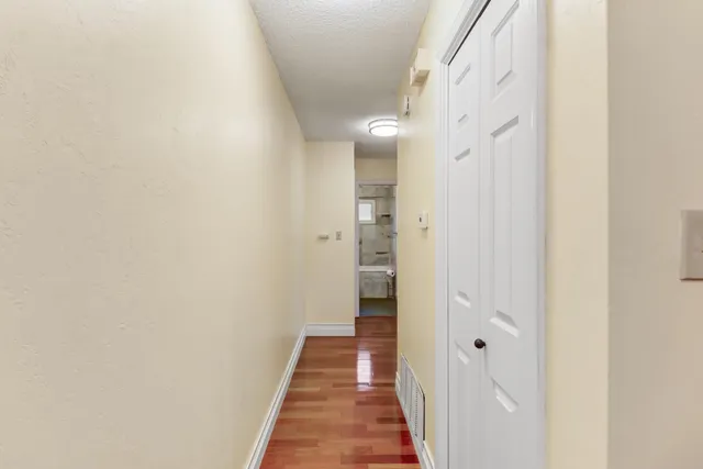 an empty room with wooden floor ceiling fan and windows