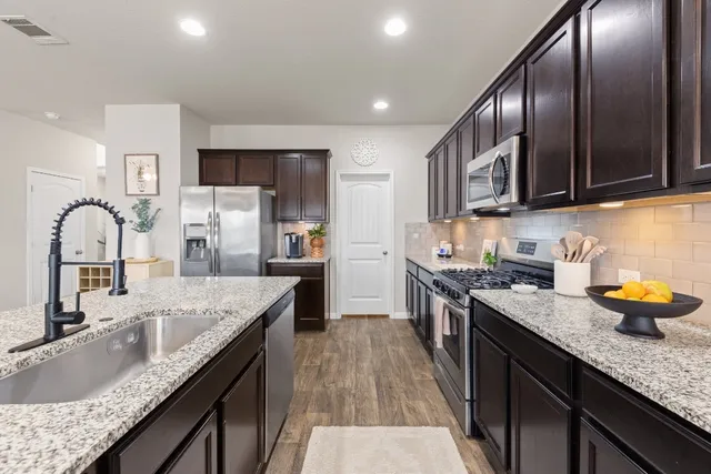 a kitchen with granite countertop stainless steel appliances and wooden cabinets