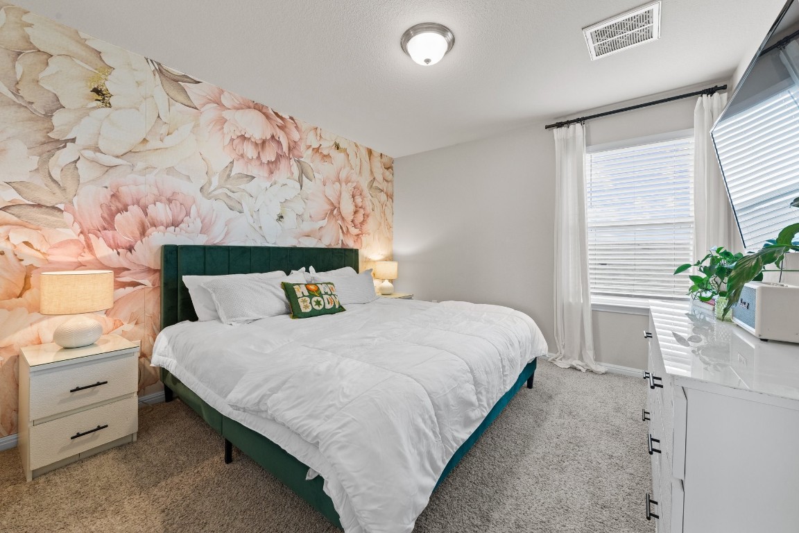 104 Blue Sage Drive Leander, TX 78641 - Photo 7 of 12 a bedroom with a bed and a potted plant