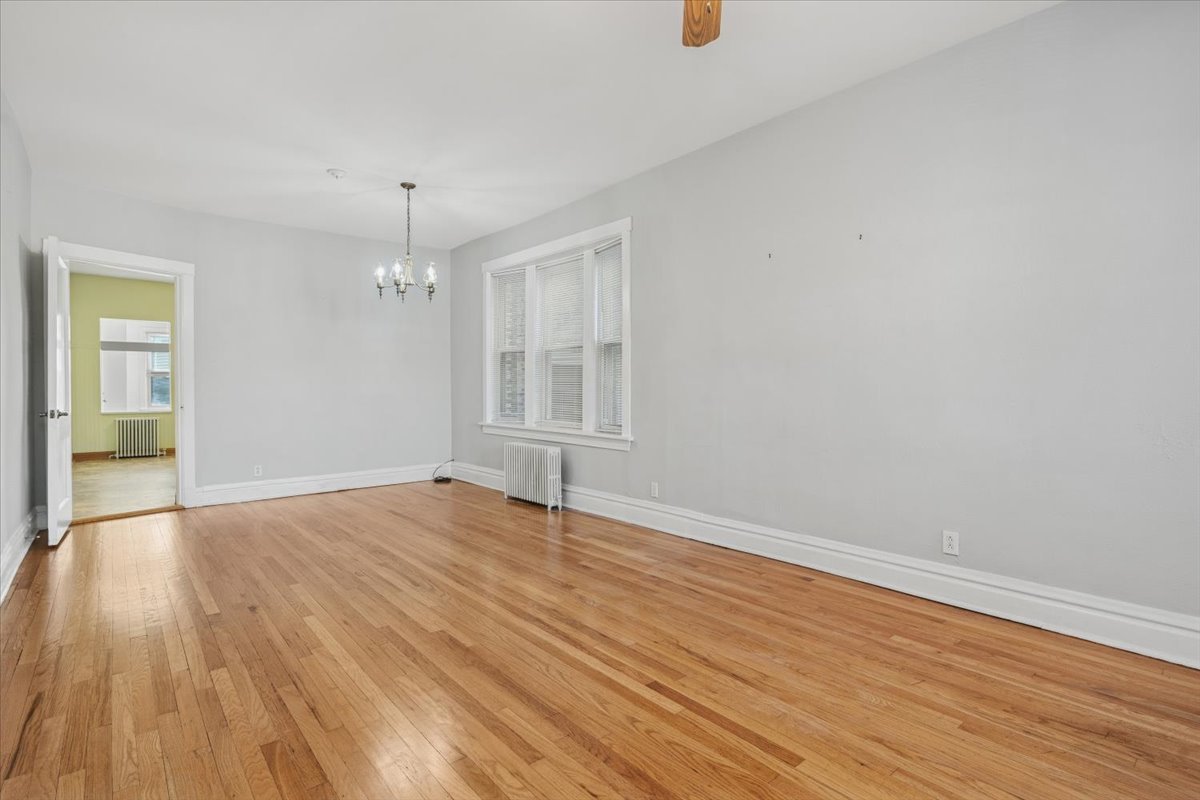 5033 West Cullom Avenue, Unit 1 Chicago, IL 60641 - Photo 3 of 20 an empty room with wooden floor and windows