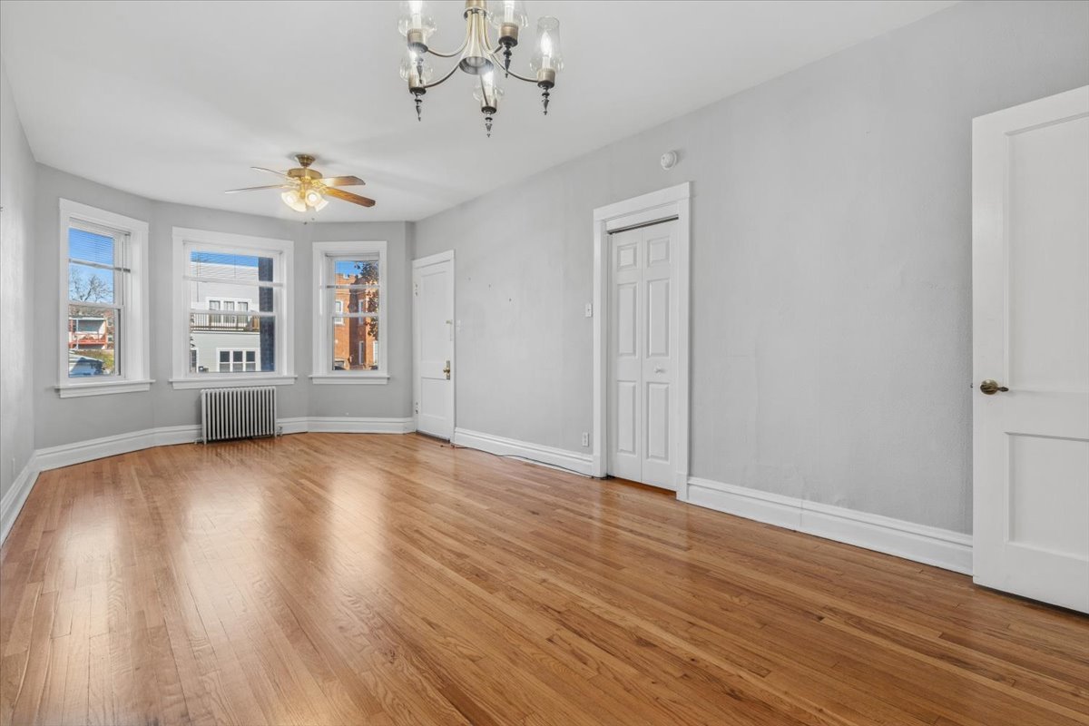5033 West Cullom Avenue, Unit 1 Chicago, IL 60641 - Photo 5 of 20 a view of an empty room with wooden floor and a window