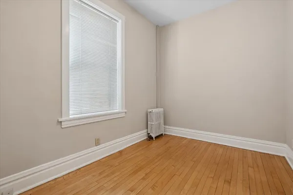 an empty room with a hardwood and a window