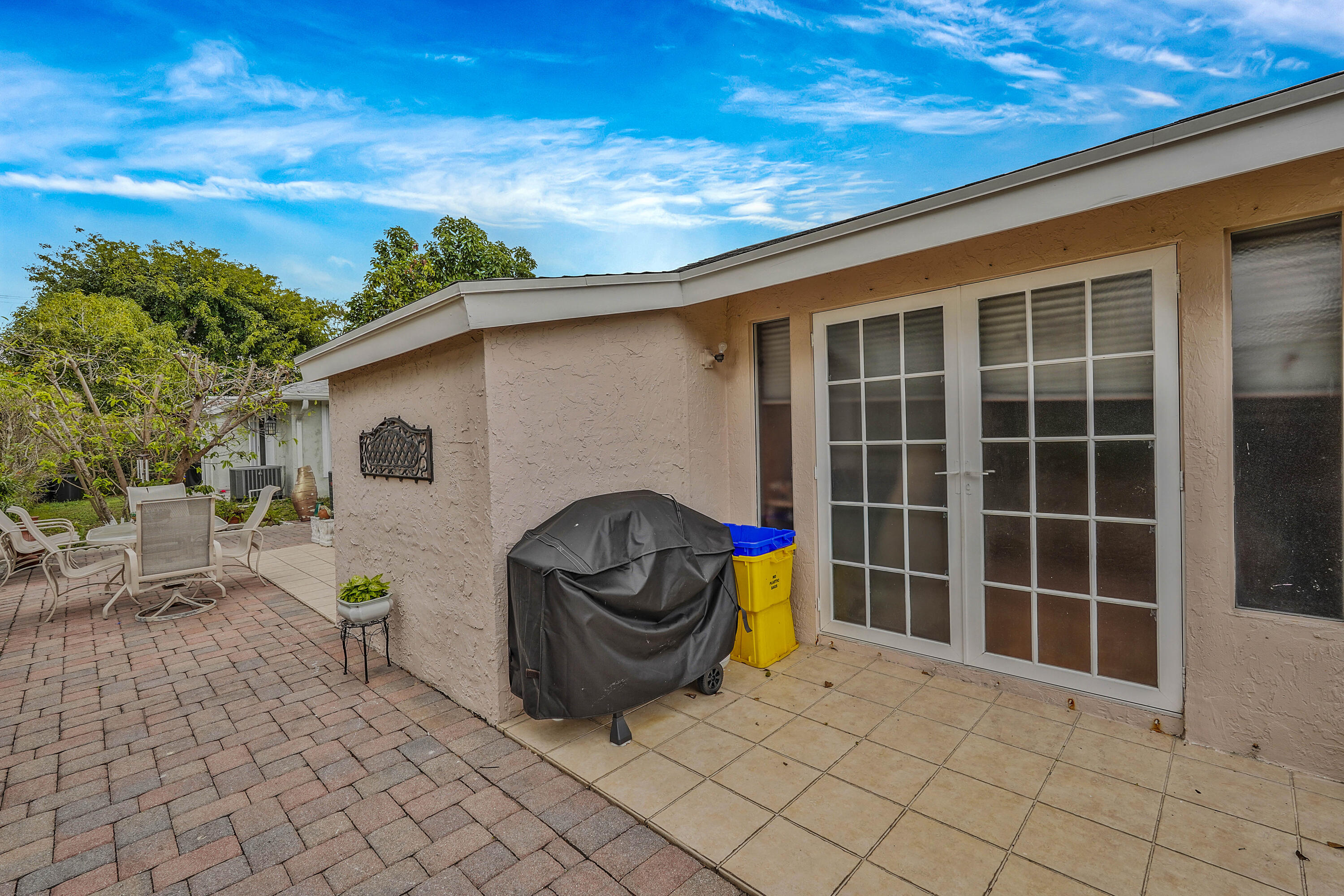 7512 Ace Road North Lake Worth, FL 33467 - Photo 15 of 25 a view of a patio with table and chairs and potted plants