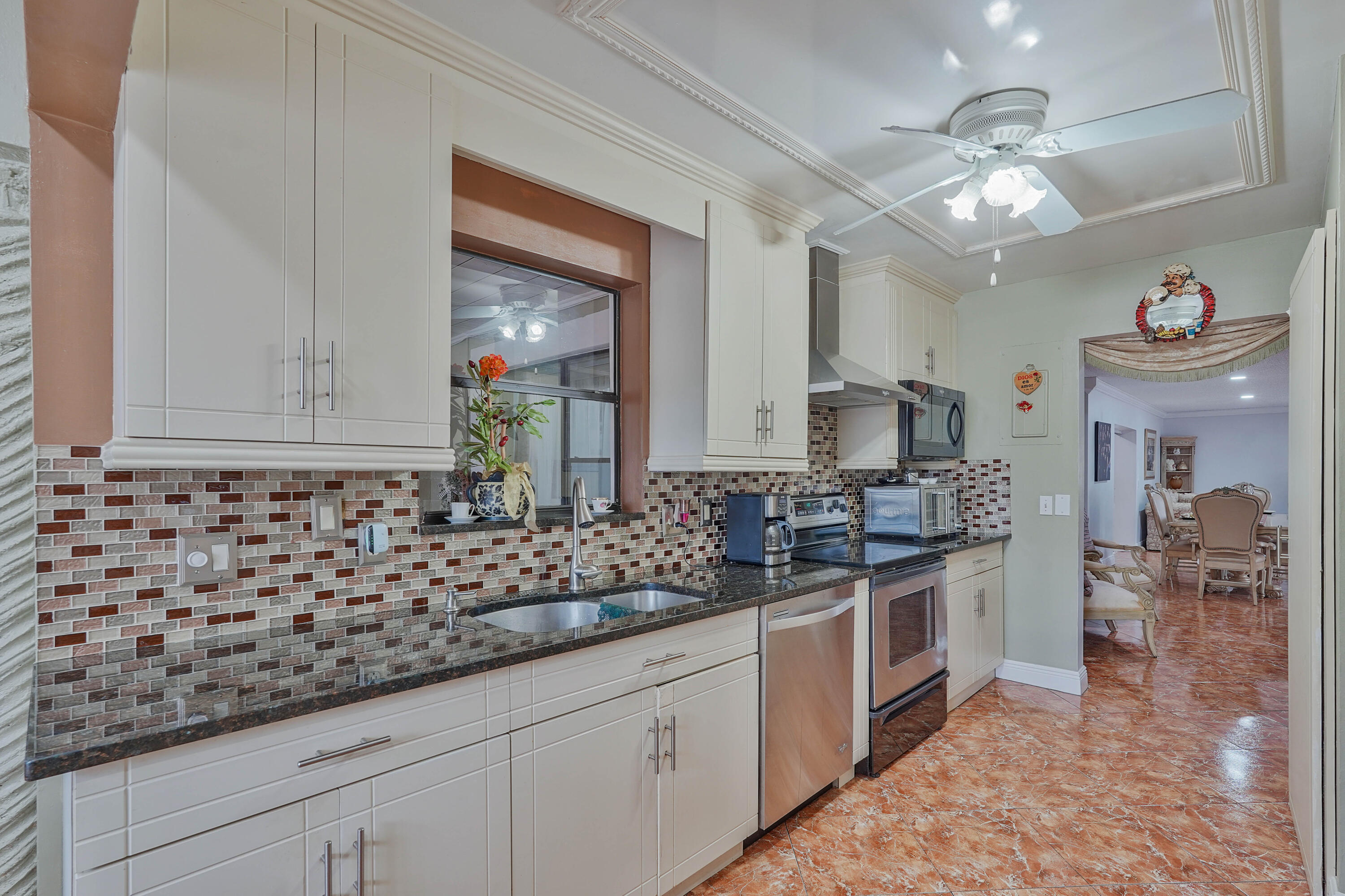 7512 Ace Road North Lake Worth, FL 33467 - Photo 2 of 25 a kitchen with stainless steel appliances granite countertop a sink and cabinets