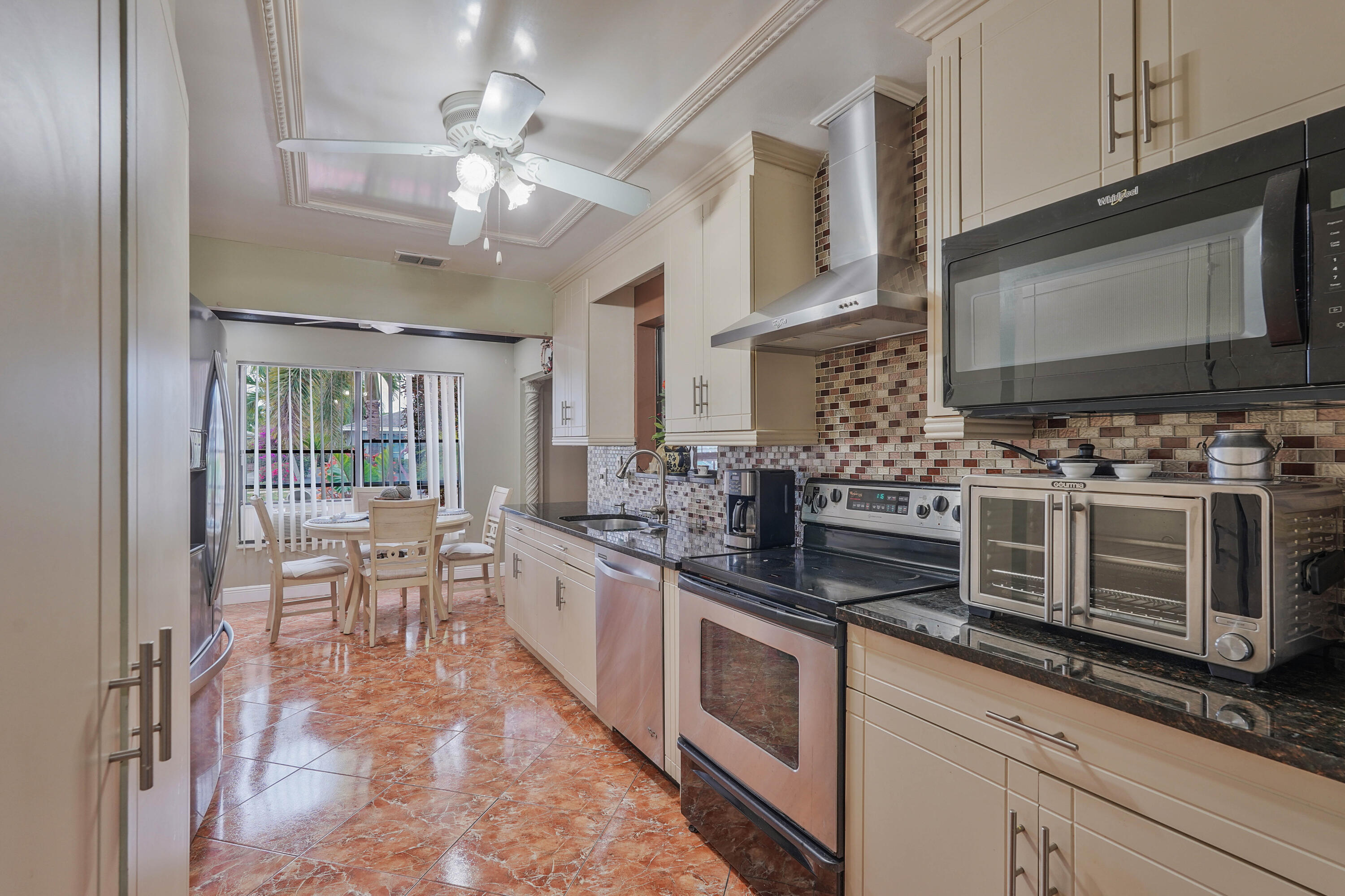7512 Ace Road North Lake Worth, FL 33467 - Photo 3 of 25 a kitchen with stainless steel appliances a stove microwave and cabinets