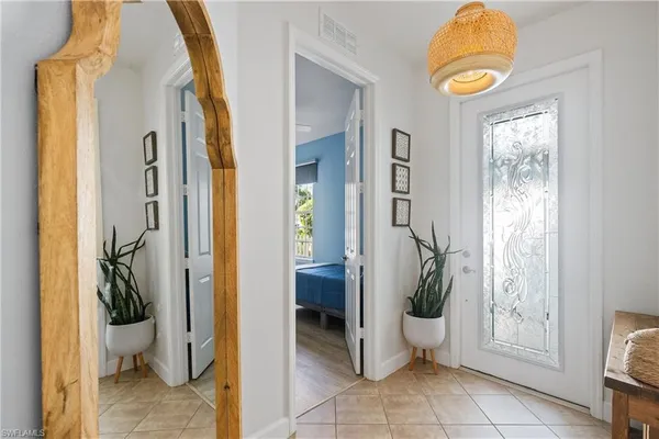 a bedroom with a bed wooden floor and a chandelier