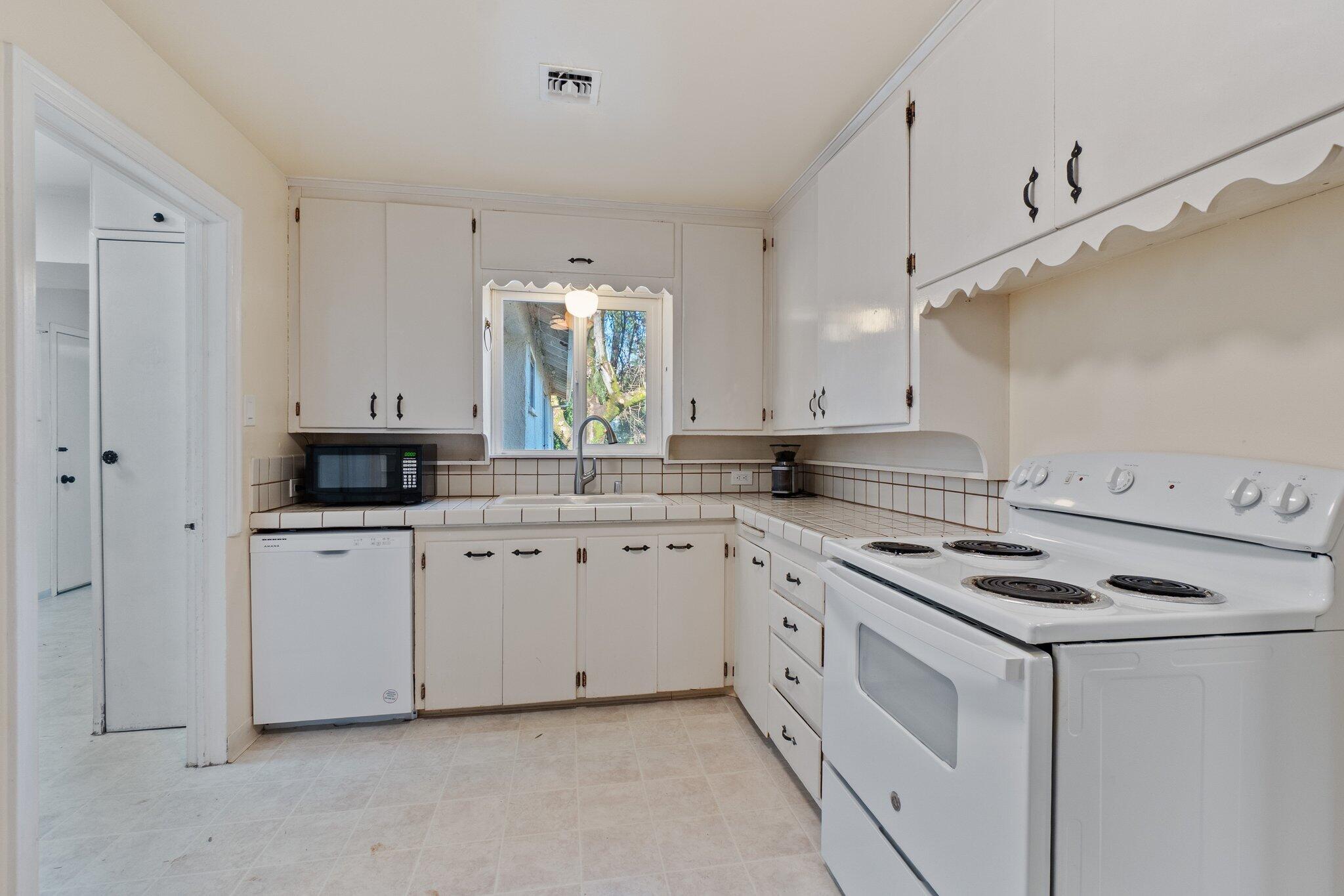 686 Coronado Street Redding, CA 96003 - Photo 15 of 39 a kitchen with white cabinets and white appliances